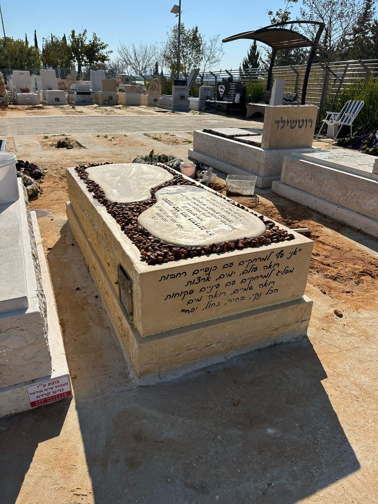 מצבה מיוחדת חלקה אחת עם אבנים שקועות בטוף בחיפה