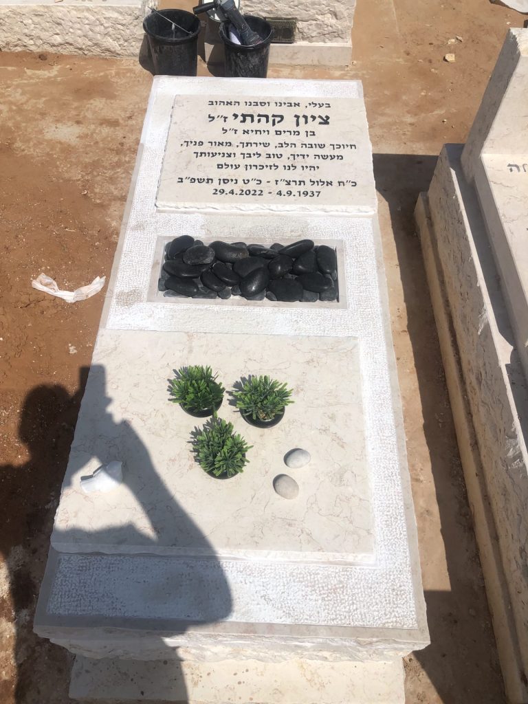מצבת מכפלה זוגית אחד מעל השני עם סיתות באבן וחלוקי נחל שחורים